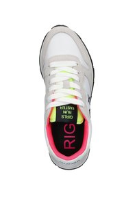 Weiße und hellgraue Sneaker mit weißen Schnürsenkeln, neon-gelbem Zungenlabel mit der Aufschrift "Mädchen laufen schneller" und pinkem Innenfutter.