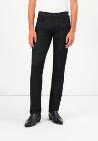 Black straight-leg jeans made from denim, featuring a classic design with a button closure and five pockets. Worn with black leather boots.