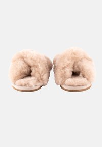Pantofole in pelliccia beige con una texture morbida e soffice e design aperto sul retro. Presentano una suola piatta con dettagli di cucitura discreti.