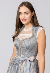 Blaue gemusterte Kleid mit einer Spitzen-Bodice, silbernen Akzenten und einem satinartigen Taillengürtel. Es hat kurze Ärmel und florale Spitzen-Akzente.