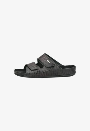Sandalia tipo slide negra con puntera abierta, dos tiras ajustables y un sutil estampado de cebra en el material superior.