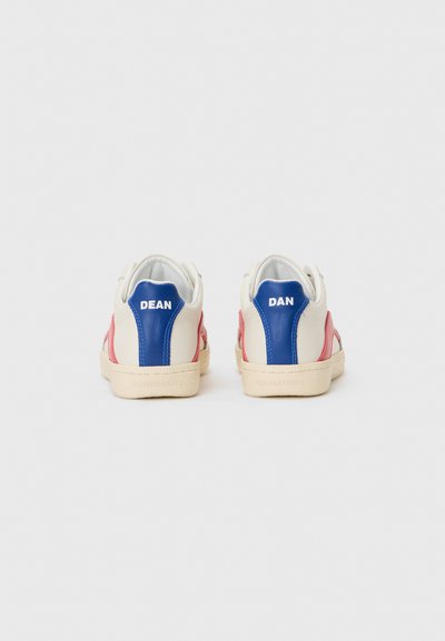 Skórzane sneakersy w kolorze kremowym, czerwonym i niebieskim. Mają naszywki na pięcie oznaczone "DEAN" i "DAN", z teksturowanymi akcentami i kremowymi gumowymi podeszwami.