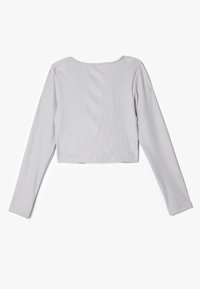 Grijze langemouwen cropped top met een ronde hals, geribbelde textuur en een aansluitend ontwerp. De stof lijkt zacht en enigszins rekbaar.