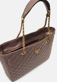 Quilted brun håndtaske lavet af syntetisk materiale, med en guld kædestropp, lynlåslomme og mærkevare metalaccent.