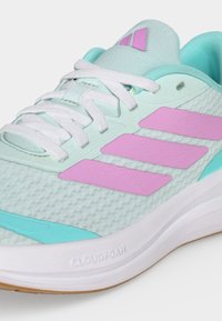 Chaussure de sport bleu clair avec lacets blancs, accents de rayures roses et semelle blanche rembourrée portant la mention "Cloudfoam."
