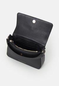 Bolso de mano de cuero negro con cierre a presión magnético, herrajes en tono dorado, bolsillo interior con cremallera y espacios para tarjetas. Textura suave, forma rectangular.