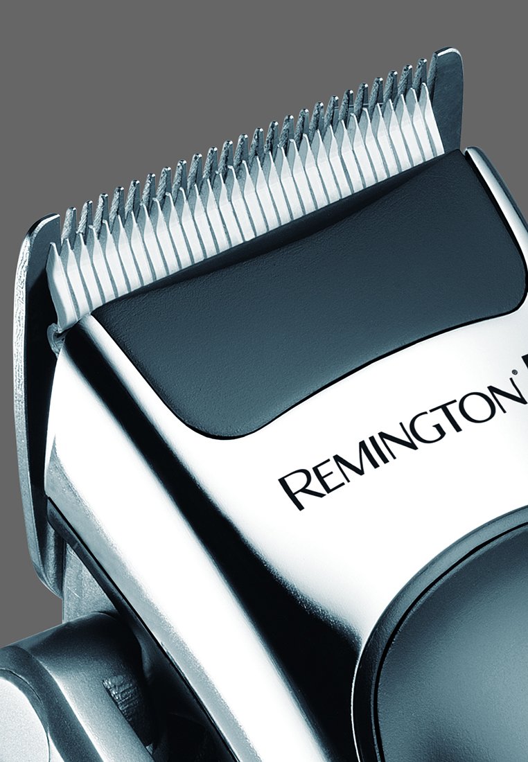 Cortadora de cabello eléctrica con acabado en cromo, empuñadura texturizada negra y cuchillas de metal plateado afiladas. Presenta un prominente logo de "Remington".
