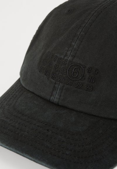 Black cotton cap with a curved brim. Features tonal embossed numbers and a circular logo on the side. Textured fabric with stitching details.