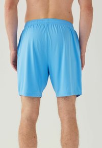 Pantaloni scurți atletici de culoare albastră deschisă, confecționați dintr-un material ușor. Proiectați cu un elastic în talie și o finisare netedă, texturată.
