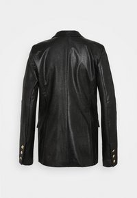 Blazer noir texturé avec une silhouette ajustée, col à revers entaillé, et boutons dorés accentuant les poignets. Vue arrière montrant des lignes et coutures lisses.