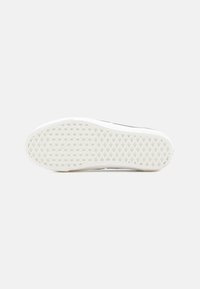 Sole de sneaker din cauciuc, alb, cu o suprafață texturată și un model în diamante. Margini ușor ridicate; zonă a călcâiului plană și netedă.