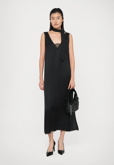 Black midi dress with thin straps and lace trim, featuring a V-neckline. Paired with a small black beaded bag and black pointed heels.