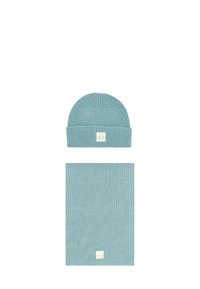 Berretto in maglia blu con risvolto e un'etichetta, abbinato a una sciarpa rettangolare coordinata. Entrambi gli articoli presentano un motivo testurizzato.