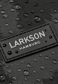 Material impermeabil negru, acoperit cu picături, având o etichetă rectangulară cu logo-ul embosat „LARKSON HAMBURG” și accente circulare.