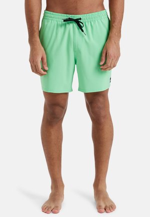 Costumi da bagno verde menta realizzati in tessuto leggero, dotati di una vita elastica con cordino nero e tasche laterali.