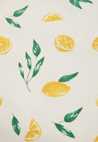 White fabric patterned with yellow lemon slices, whole lemons, and green leaves scattered across the surface.