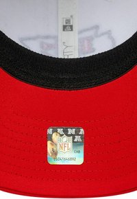 Gorra de béisbol roja con una visera negra y texturizada. Presenta un parche de la NFL en el interior con gráficos de fútbol y códigos de barras.