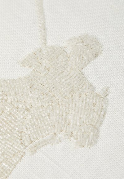 Beaded stof met een lichtbeige ontwerp, getextureerd met kleine glazen kralen op een crèmekleurige achtergrond, wat een subtiele dimensie-effect creëert.