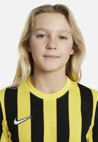 Maglia Nike con strisce verticali nere e gialle, colletto rotondo e un piccolo logo bianco sul lato sinistro. Tessuto morbido.