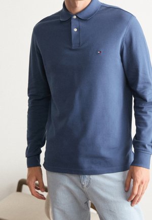 Navyblaues Langarm-Polohemd mit Kragen und drei Knöpfen, ausgestattet mit einem kleinen Logo auf der linken Brust und gerippten Bündchen. Glattes Baumwollmaterial.