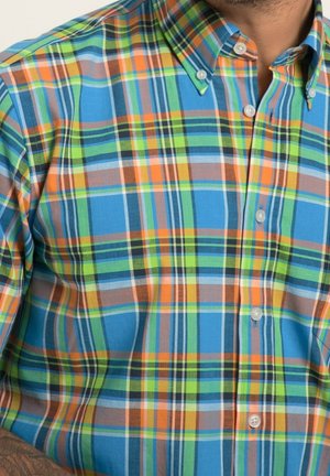 Geklede hemd met blauwe, groene, oranje en bruine tinten. Kraagontwerp met knoopsluitingen en korte mouwen. Katoenen stof.