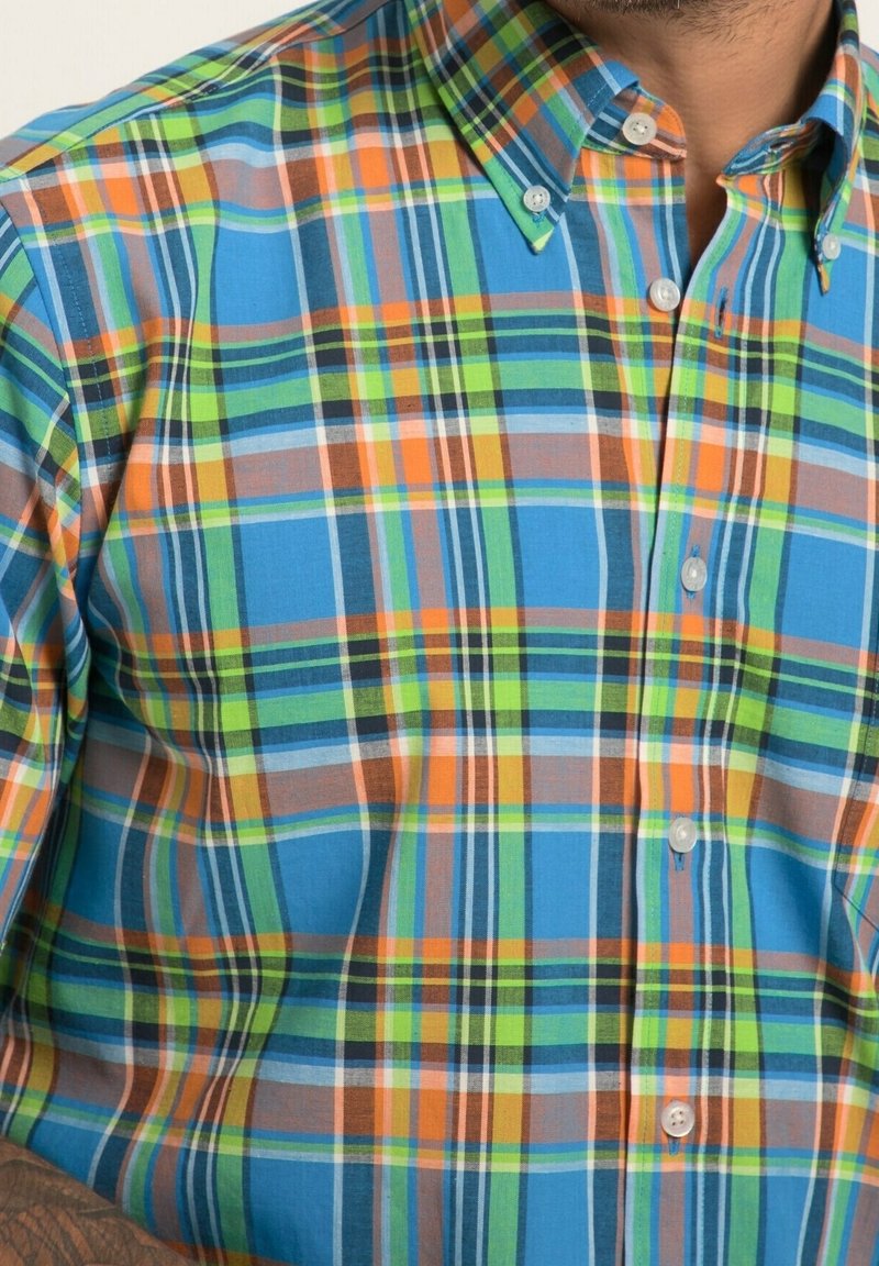 Kostkovaná košile v modrých, zelených, oranžových a hnědých tónech. S límečkem, zapínáním na knoflíky a krátkými rukávy. Bavlněný materiál.