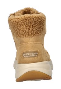 Botín impermeable marrón hasta el tobillo con un suave y peludo cuello. Presenta un exterior de ante texturizado y una suela de goma gruesa para mayor agarre.