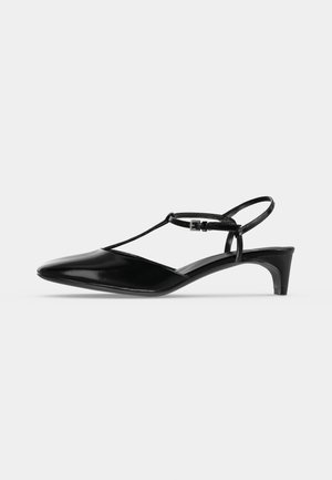 Zapato slingback de charol negro con punta afilada, tacón pequeño kitten y tira delgada en el tobillo con cierre de hebilla.