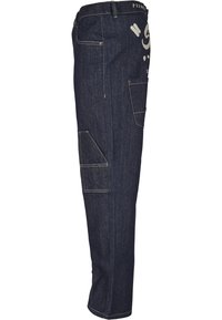Pantalon cargo en denim bleu foncé avec multiples poches, coutures contrastantes et coupe décontractée. Il présente un imprimé graphique sur le côté.