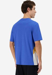 Camiseta de hombre de manga corta azul, hecha de tela suave; presenta un diseño a bloques de color con acentos amarillos y blancos en los lados.