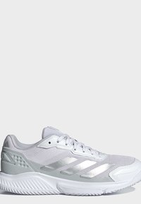 Baskets blanches de sport avec des rayures argentées, dessus en mesh et semelle texturée, vues de côté sur un fond clair uni.
