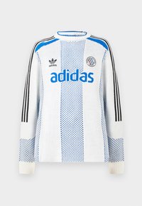Bela pulover jopica z modrim črtastim vzorcem in logotipom "adidas". Ima črne ramenske črte in rebraste manšete. Teksturna pletenina.
