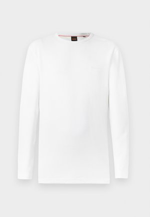 Pikad varrukadega valge T-särk tekstureeritud materjalist, millel on ümarsäär ja keskel peen embosseeritud logo.