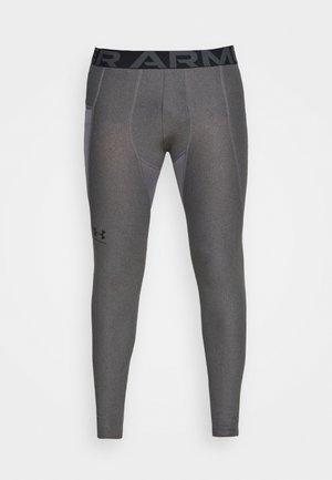 Leggings de sport gris avec une taille noire portant "ARMOUR" en lettres grasses. Fabriqués en tissu extensible avec une finition lisse et texturée.