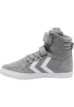 Szary wysoki trampek z białymi paskami w kształcie szewrona, sznurowany z przodu, z wyściełanym kołnierzem wokół kostki i paskiem na rzep na białej podeszwie.