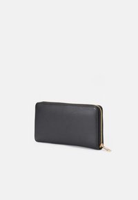 Portofel din piele neagră, cu formă rectangulară, fermoar aurit, textură netedă și design minimalist.