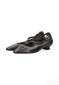 Ballerine in pelle nera con punta affusolata, dettagli in stud dorati lungo i bordi e un tacco basso e angolare. Due cinturini sopra.