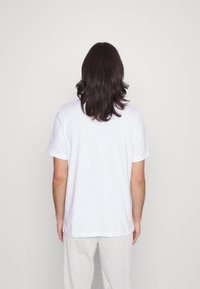White cotton t-shirt with short sleeves, featuring a classic round neckline and a regular fit, shown from the back.