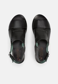 Sandali in pelle nera con accenti turchesi, caratterizzati da un design con punta aperta e una cinghia regolabile alla caviglia. Texture liscia con dettagli intagliati.