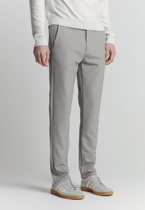 Light gray tailored pants with a smooth texture, featuring front pleats, side pockets, and paired with gray athletic shoes.