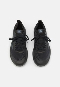 Scarpe sportive nere con una parte superiore in tessuto texturizzato, lacci tono su tono e un logo impresso sulla linguetta. Presentano una punta arrotondata e una soletta imbottita.