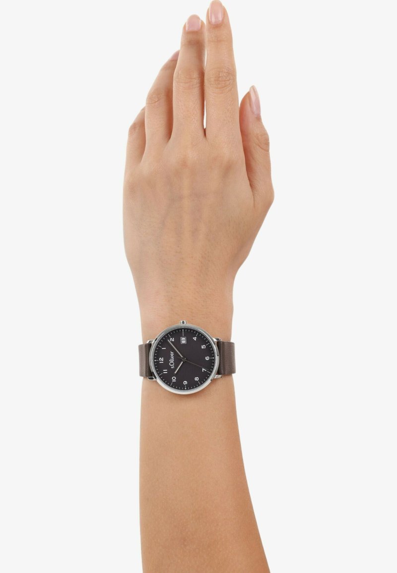 Schwarze Uhr mit silbernen Akzenten an einem braunen Lederarmband, mit einem klaren Ziffernblatt, das Zahlen und eine Datumsanzeige auf der rechten Seite zeigt.