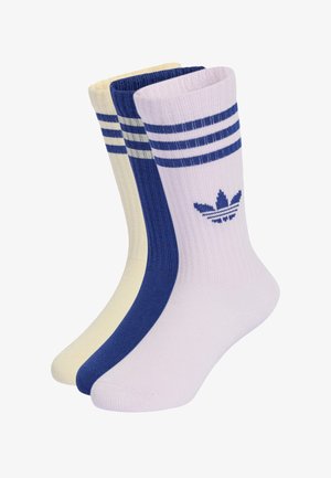 Kolme paria Adidas crew-sukkia valkoisena, sinisenä ja kermanvärisenä, jokaisessa kolme vaakasuoraa raitaa ja Adidas trefoil -logo.