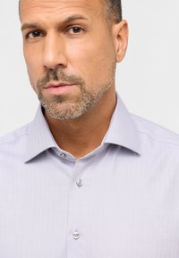 Hellblaues Button-up-Hemd mit einem Fischgrätmuster. Verfügt über einen Kentkragen, silberne Knöpfe und einen strukturierten Stoff.