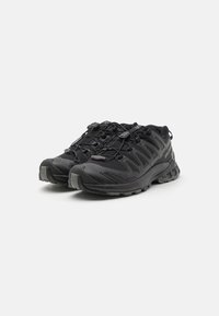 Scarpe da atletica nere con tomaia in mesh traspirante, dettagli testurizzati e suola in gomma resistente. Presentano lacci elasticizzati e punta rinforzata.