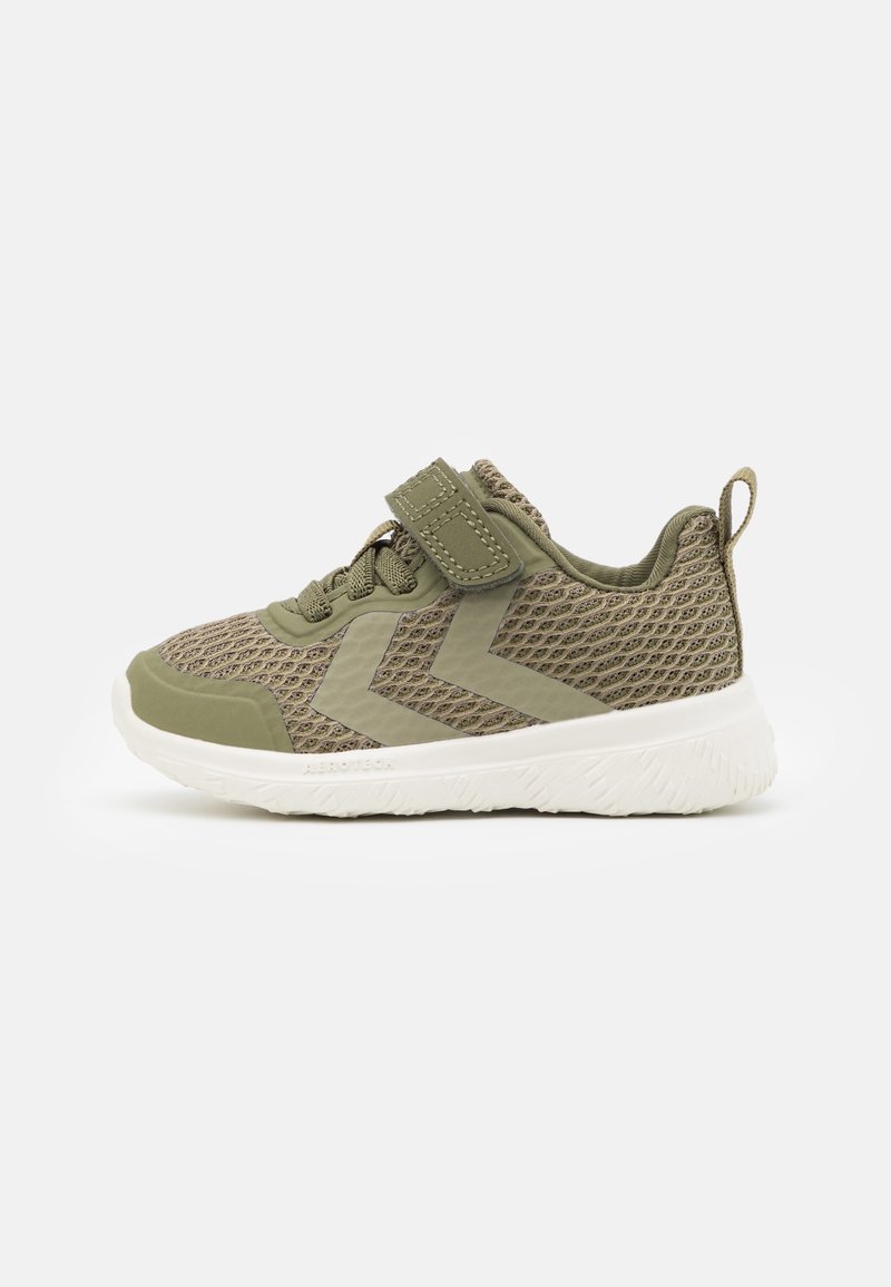 Zapatilla deportiva de color verde oliva claro con parte superior de malla, banda de Velcro, cordones, patrón de chevron y suela blanca gruesa y texturizada.
