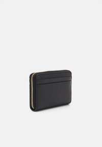 Black leather cardholder with textured surface, three card slots, and a gold zip closure along the side. Compact rectangular design.