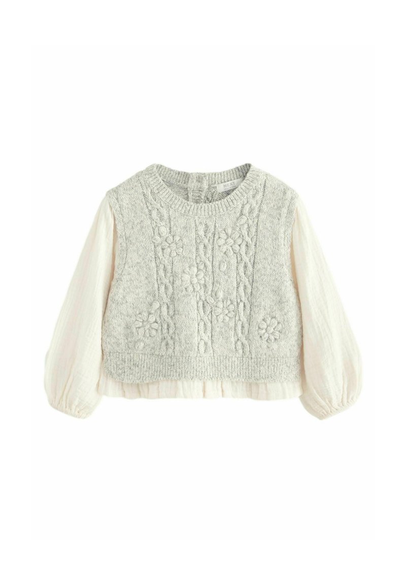 Pull en tricot avec un buste texturé gris clair et des motifs floraux brodés, présentant des manches bouffantes crème et un ourlet court.