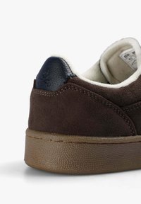 Bruna mockasiner i mocka med en slät navy läderhäll. Har en strukturerad gummisula och krämfärgad foder för komfort.