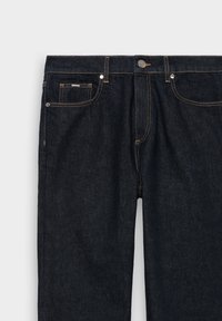 Donkerblauwe denim jeans met een voorknop, ritssluiting, riemlussen en gele stiksels op de zakken en naden.